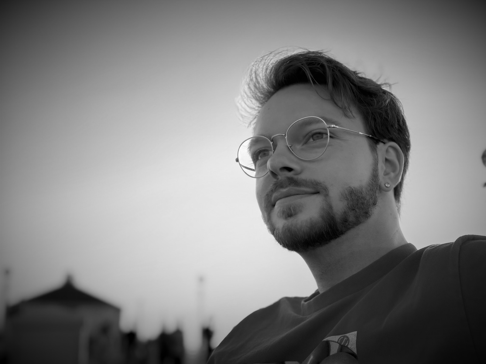 Hal Whitman outdoors at sunset, in glasses and a red shirt, looking past the camera.